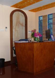 a wooden desk with flowers on it in a room at Room For You in Bangkok