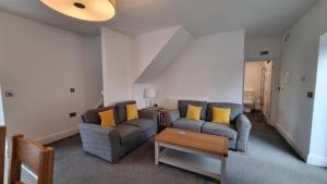 a living room with two couches and a table at Cottage #1 in Aberystwyth