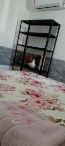 un letto con fiori rosa sopra e una scala di Casa Aeroporto - UFAL a Maceió