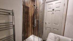 a shower with a glass door in a bathroom at Cottage #1 in Aberystwyth