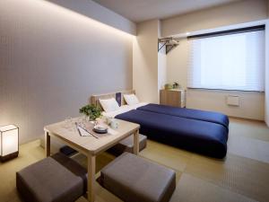 a bedroom with a blue bed and a table at Minn Ueno Shin-Okachimachi in Tokyo