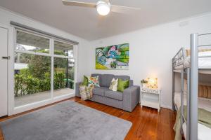 a living room with a couch and a bunk bed at Cosy Coastal Beach Cottage in Rye in Rye