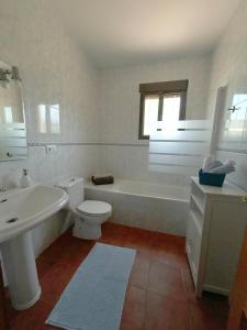 a white bathroom with a tub and a toilet and a sink at Casa rural Juan Pablo in Segura de la Sierra +23 photos