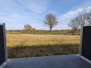 an open door with a view of a field at Huk's 5 - Aurora Vista - ABC580 - nur Feriengäste! in Hohen Wieschendorf
