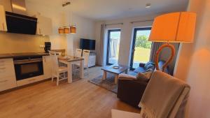 a living room with a couch and a kitchen with a table at Huk's 5 - Aurora Vista - ABC580 - nur Feriengäste! in Hohen Wieschendorf