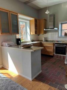 a kitchen with wooden cabinets and a counter top at Kutscherremise Gut Niendorf - ABC592 - nur Feriengäste! in Bad Kleinen +27 photos