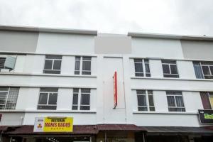 a white building with a yellow sign in front of it at 988 Hotel in Johor Bahru