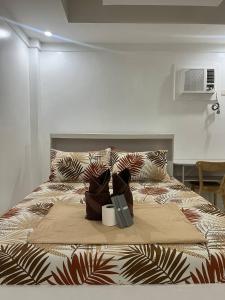 エルニドにあるCarandang Tourist Innの2つのバッグと本が置かれたベッド