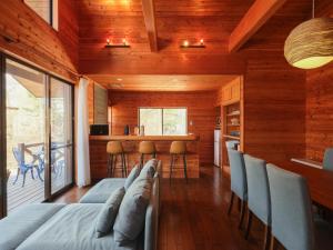 a room with a bed and chairs and a kitchen at 聖翔庵 in Tsumagoi