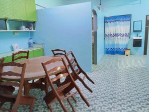 a kitchen with a table and chairs and a blue wall at 51 SpS HOMES in Bagan Serai