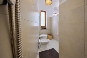 a bathroom with a toilet and a sink at Casetta Limone Loft in Gavorrano +20 photos