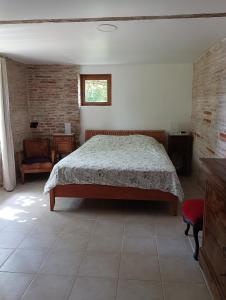 ein Schlafzimmer mit einem Bett und einem Stuhl und einem Fenster in der Unterkunft L'Eden des Pyrénées in Lézat-sur-Lèze