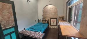 a room with a bed and a wooden table at La Maison d'art de Hanoi in Hanoi