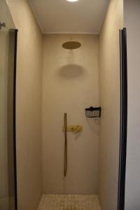 ein Bad mit einer Dusche mit einem Kreuz an der Wand in der Unterkunft Apartamento Sol de Maro in Maro + 24 Fotos