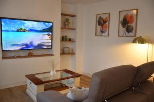 ein Wohnzimmer mit Sofa und Flachbildfernseher in der Unterkunft Apartamento Sol de Maro in Maro