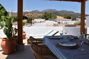 einen Tisch mit Tellern und Weingläsern auf einer Terrasse in der Unterkunft Apartamento Sol de Maro in Maro