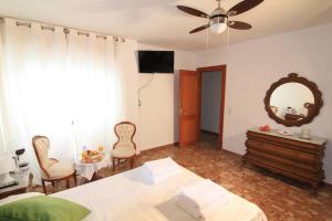 a bedroom with a bed and a mirror and chairs at Casa Cándida in Almería +8 photos