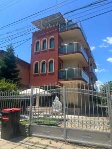 a building behind a fence in front of a building at Къща за гости STEDY in Chernomorets