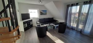 un salon avec un canapé et une télévision dans l'établissement Ferienwohnung Claudia, à Carolinensiel 24 autres photos