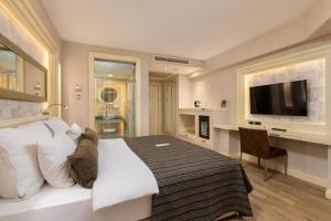 a bedroom with a bed and a desk and a television at Limak Eurasia Luxury Hotel in Istanbul