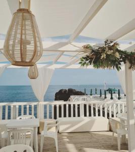 een paviljoen met witte stoelen en uitzicht op de oceaan bij Santa Caterina da Siena B&B in Catania
