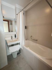 a white bathroom with a tub and a sink at Sunset Apartments in Podstrana +47 photos