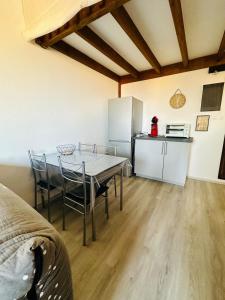 a kitchen with a table and chairs in a room at Le cosy vue mer in Fleury