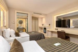 a hotel room with two beds and a television at Limak Eurasia Luxury Hotel in Istanbul