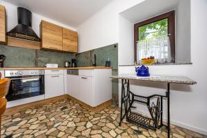 een keuken met witte kasten en een tafel en een raam bij MICIKA Country house in Grižane +24 foto's