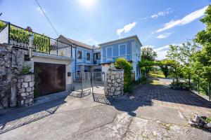 een blauw huis met een poort en een oprit bij MICIKA Country house in Grižane