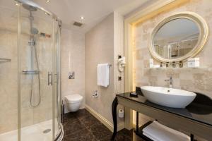 a bathroom with a sink and a shower and a toilet at Limak Eurasia Luxury Hotel in Istanbul