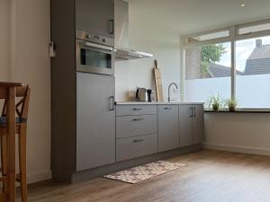 a kitchen with stainless steel appliances and a window at Gastenverblijf Bladel in Bladel