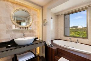 a bathroom with a tub and a sink and a mirror at Limak Eurasia Luxury Hotel in Istanbul