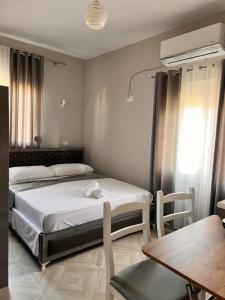 a bedroom with two beds and a table and a dining room at Vila Zini in Vlorë