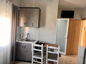 a small kitchen with a sink and a table and chairs at Vila Zini in Vlorë