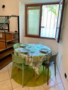 a dining room table with blue plates and chairs at Old Porlezza Apartment in Porlezza
