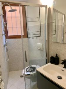 a bathroom with a shower with a toilet and a sink at Old Porlezza Apartment in Porlezza +32 photos