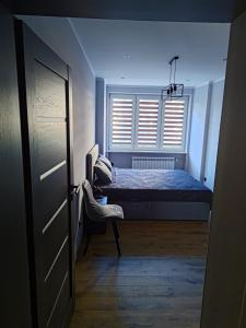 ein kleines Schlafzimmer mit einem Bett und einem Fenster in der Unterkunft Apartament u Jacka - 400m od Zamojskiej Starówki in Zamość