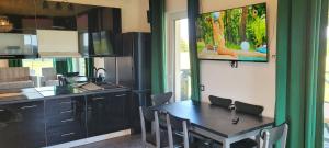 een keuken met een tafel en stoelen en een tv bij Domek nad jeziorem Potoczek, Giże in Giże