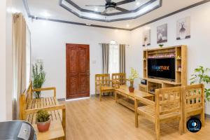 a living room with a tv and wooden furniture at JudyandRobert RentalHouse in Tagbilaran City