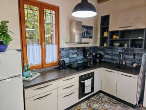 une cuisine avec des armoires blanches et un comptoir noir dans l'établissement Residence Katrins, à San Giorgio in Salici 14 autres photos