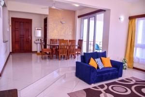 a living room with a blue couch and a dining room at Iko homes in Mombasa