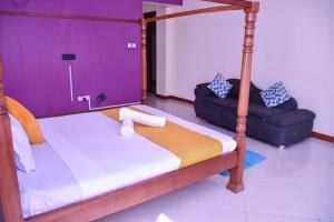 a bedroom with a canopy bed and a chair at Iko homes in Mombasa +23 photos