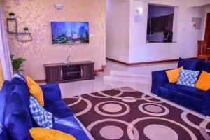 a living room with blue couches and a tv at Iko homes in Mombasa