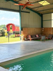 un pabellón con piscina y una casa en La roulotte Champêtre des Grillots, en Beaulon