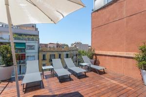 a patio with chairs and an umbrella on a building at My Space Emirates - Fully equipped apartments near the Beach with shared pool in Barcelona +27 photos