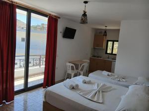 two beds in a room with a view of the ocean at Villa Allkushi in Sarandë +77 photos