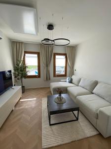 a living room with a white couch and a table at Casa Cabini Piave in Eraclea