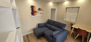 a living room with a blue couch and a table at Quinta Nova in Cadaval +17 photos