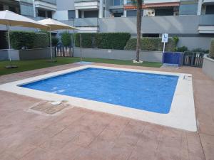 a large blue swimming pool in front of a building at Tikitita House in Gandía